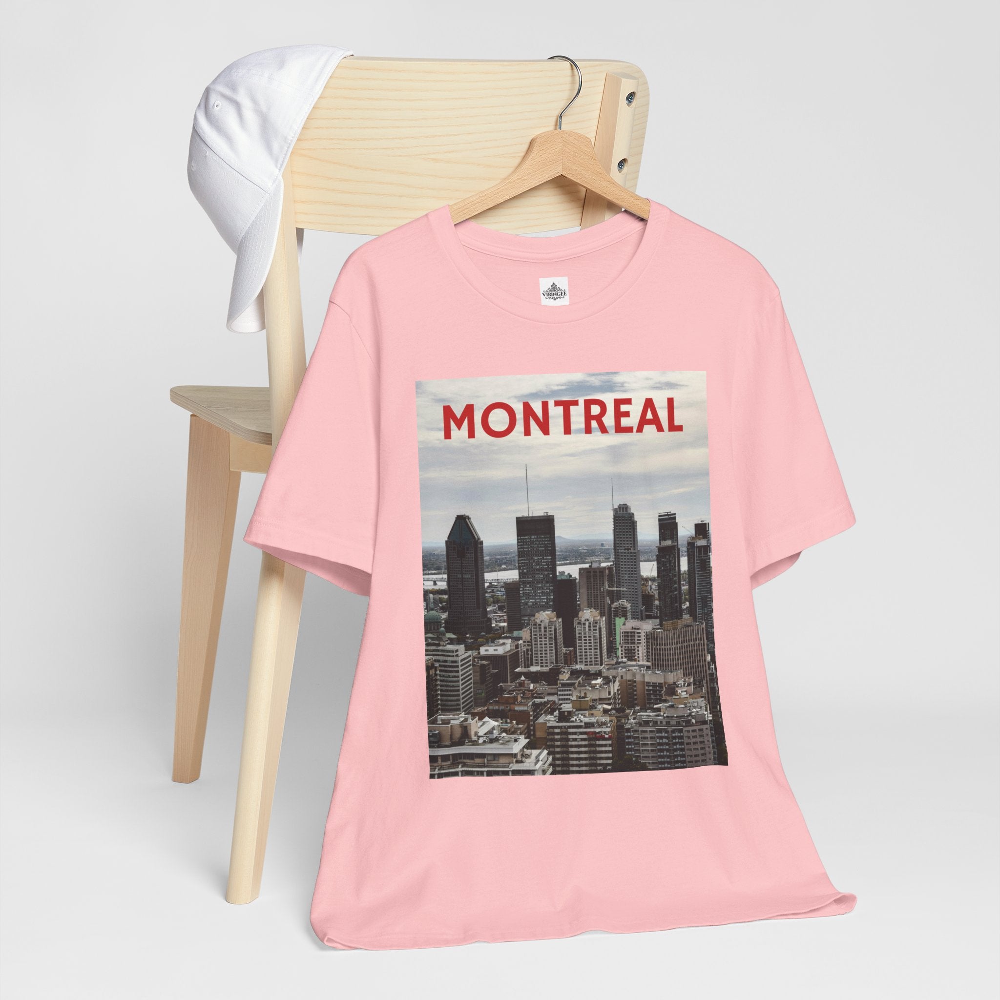 Pink t-shirt with Montreal skyline graphic on a wooden chair